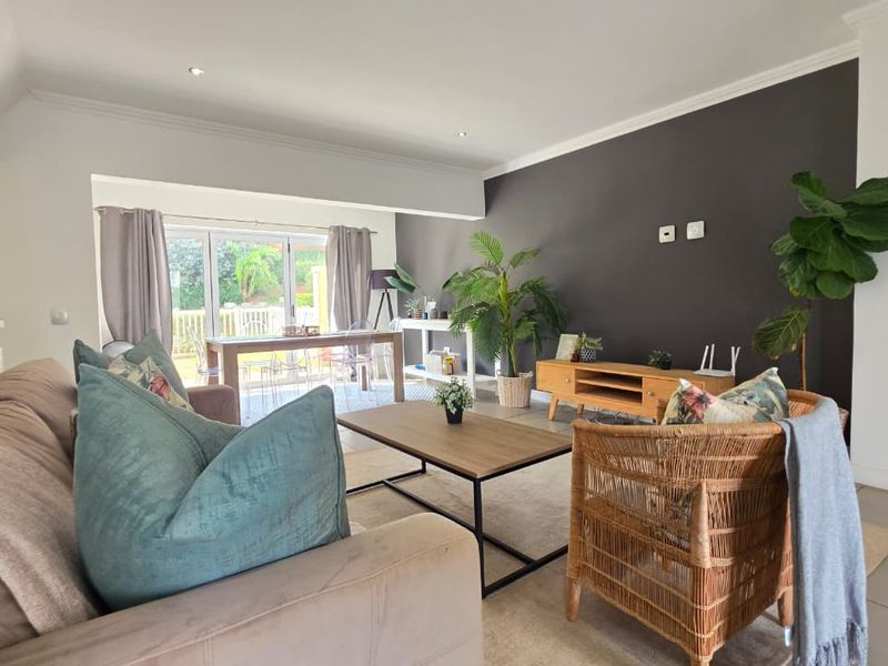 Spacious open-plan living and dining area featuring tiled floors, recessed lighting, and large sliding glass doors providing access to the outdoor space.