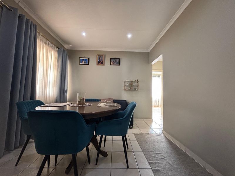 A functional dining room featuring tiled flooring and recessed downlighting, providing a neutral space for family meals and entertaining.