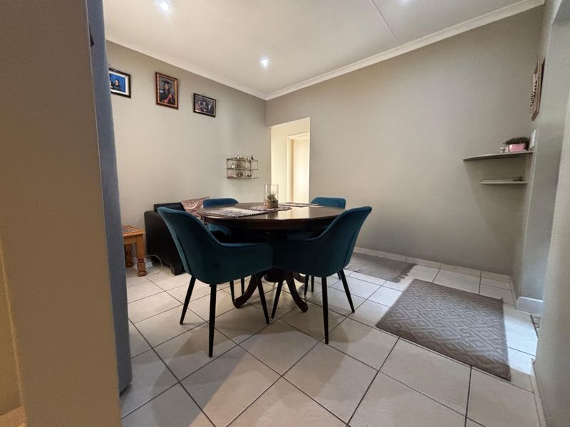 A functional dining area featuring neutral wall tones, tiled flooring, and recessed downlighting, providing a clean and versatile space for meals.