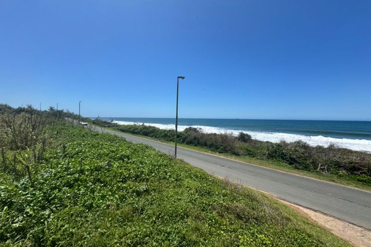 A scenic view of the coastal road adjacent to the ocean, showcasing the property's proximity to the coastline.