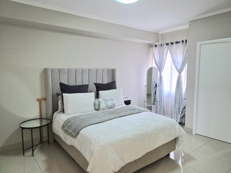 A well-maintained bedroom featuring neutral wall tones, tiled flooring, and clean architectural finishes, providing a bright and comfortable living space.