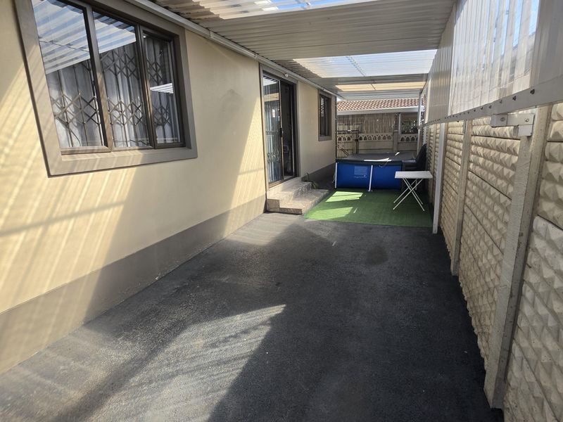 A covered outdoor patio area featuring a translucent roof, paved flooring, and direct access to the home through a sliding door.