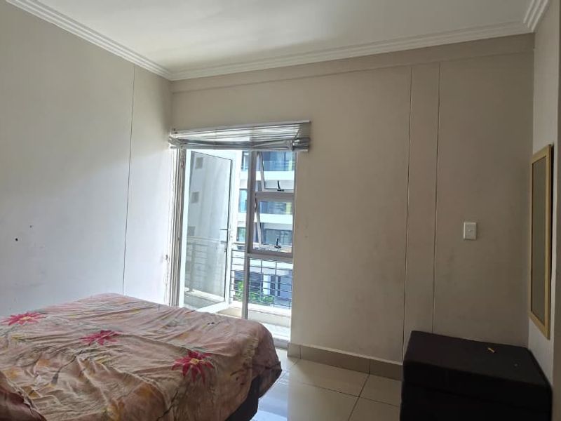 A bedroom featuring tiled flooring, coving, and a sliding glass door providing access to a balcony.