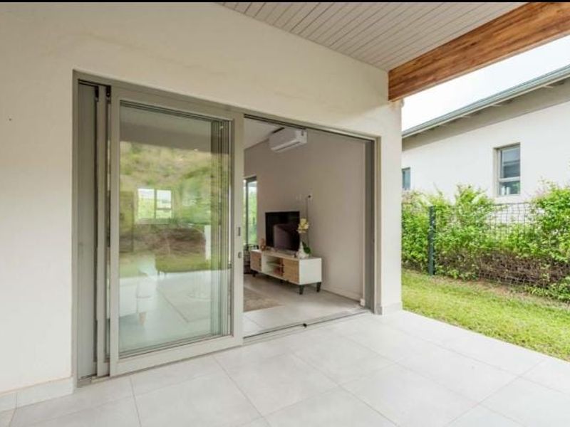 A covered patio featuring tiled flooring and large sliding glass doors that provide seamless access to the interior living space.