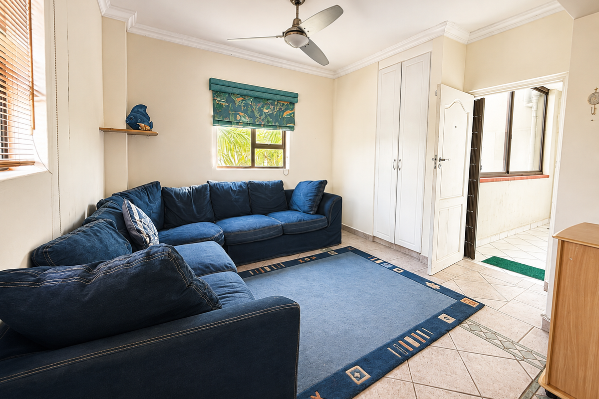 A living room featuring tiled flooring, a ceiling fan, and built-in storage cupboards, with direct access to an outdoor balcony area.