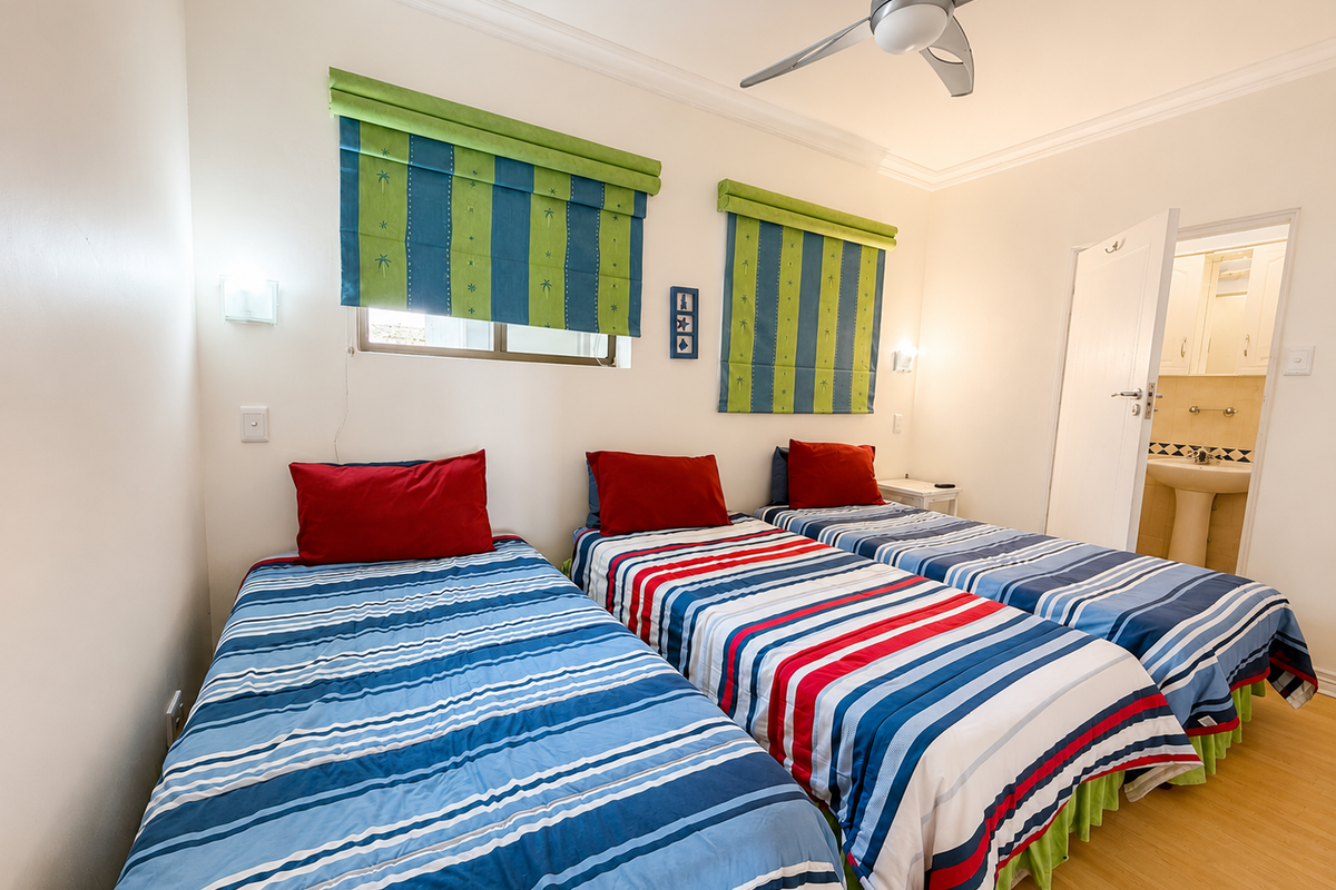 A bedroom featuring laminate flooring, a ceiling fan, and direct access to an en-suite bathroom.