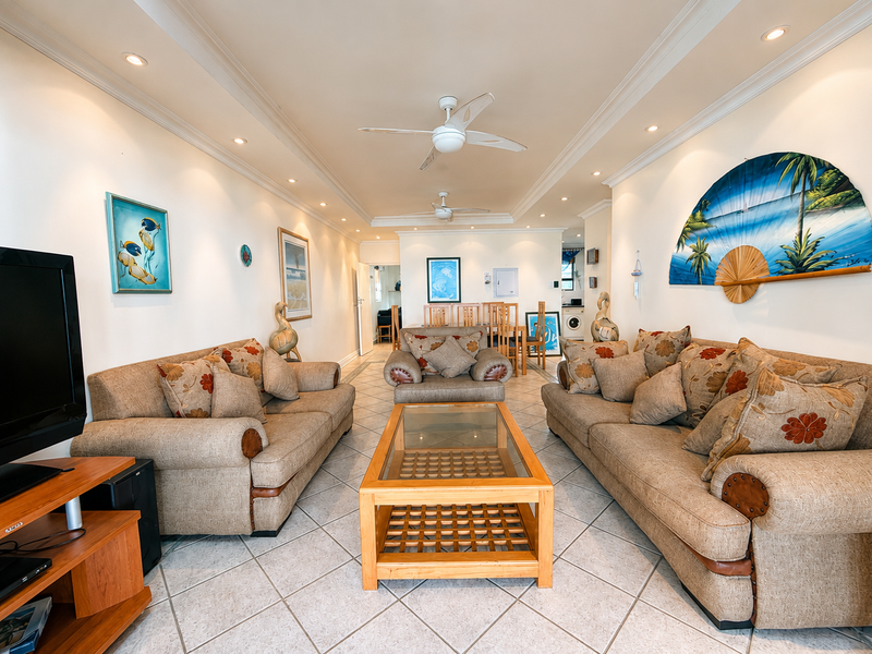 Spacious open-plan living and dining area featuring tiled flooring, recessed lighting, and ceiling fans, creating a bright and comfortable atmosphere.