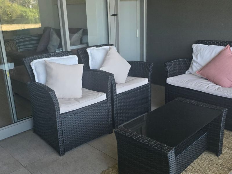 A covered balcony featuring tiled flooring and large sliding glass doors providing access to the interior living space.