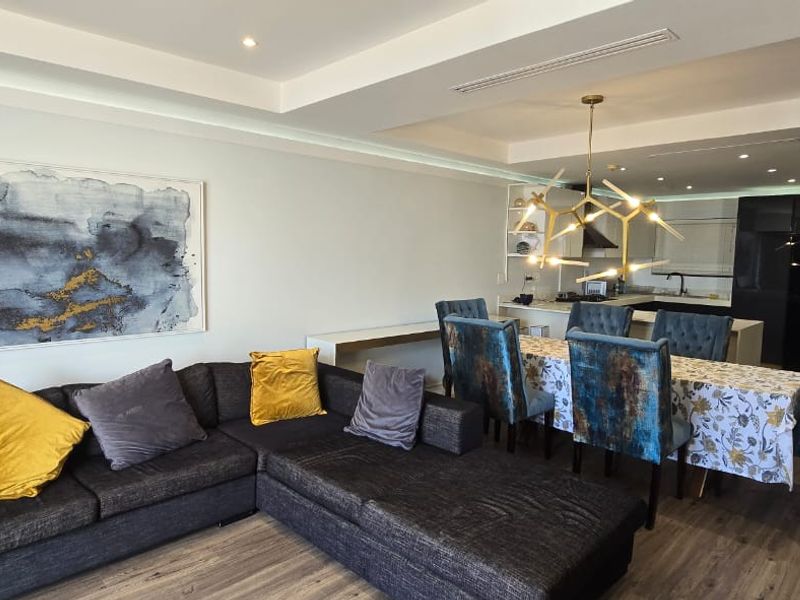 Spacious open-plan living and dining area featuring modern recessed lighting, ducted air conditioning, and a sleek kitchen with integrated cabinetry.