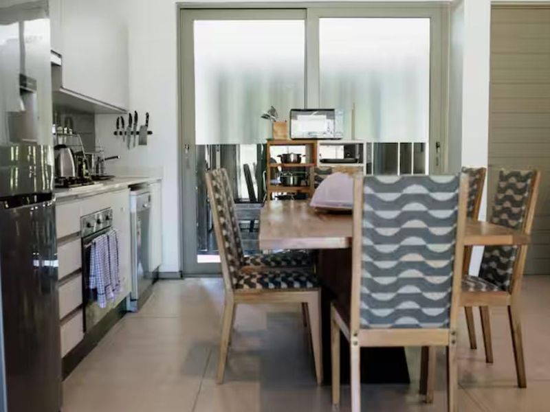 Open-plan kitchen and dining area featuring modern cabinetry, built-in oven, hob, and large sliding glass doors leading to an outdoor space.