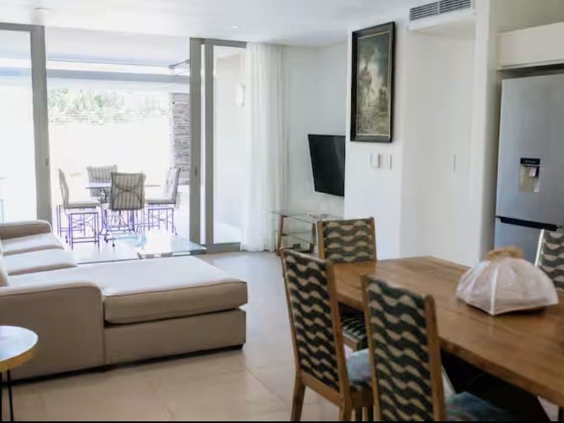 Bright open-plan living and dining area featuring large sliding glass doors that provide seamless access to the outdoor patio space.