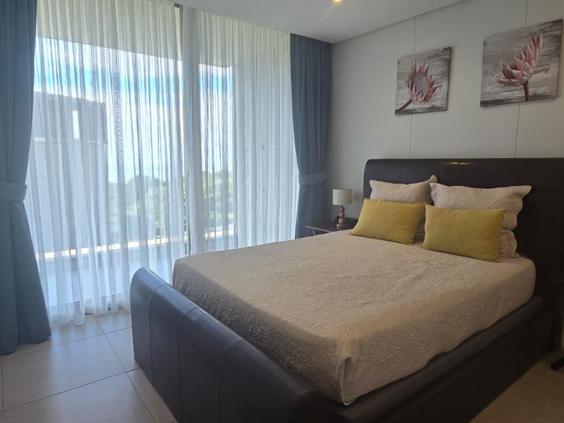 A well-maintained bedroom featuring built-in cupboards, tiled flooring, and large sliding glass doors that provide access to an outdoor area.