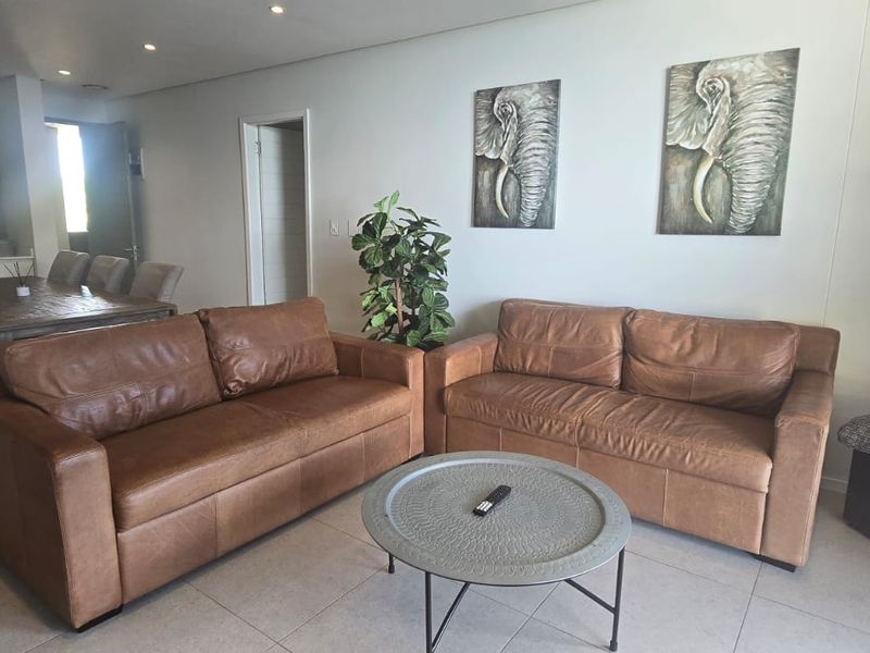 Spacious open-plan living and dining area featuring neutral tiled flooring and recessed downlighting, creating a bright and functional layout.