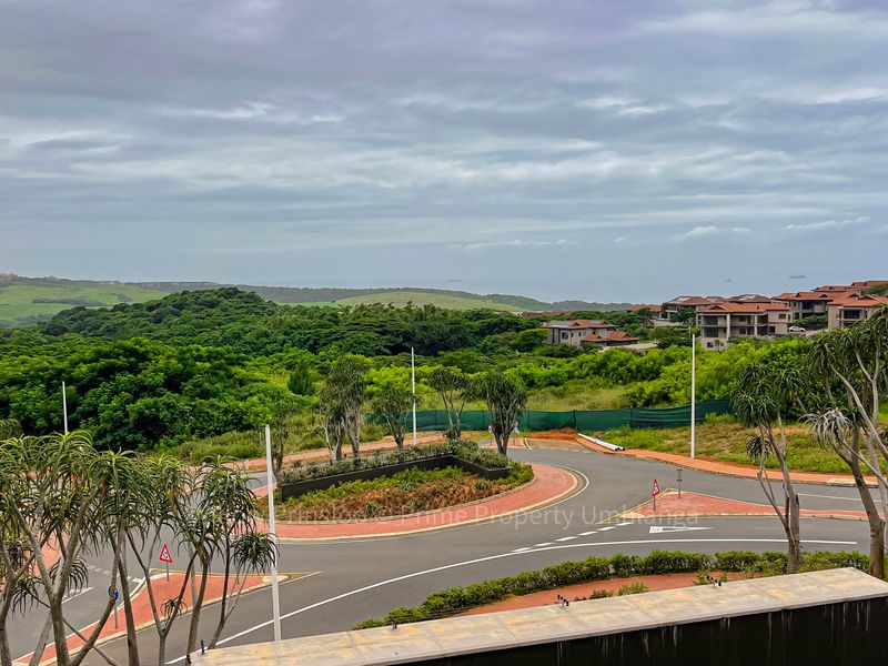 Elevated scenic view overlooking the surrounding landscape, local road infrastructure, and nearby residential developments under a cloudy sky.