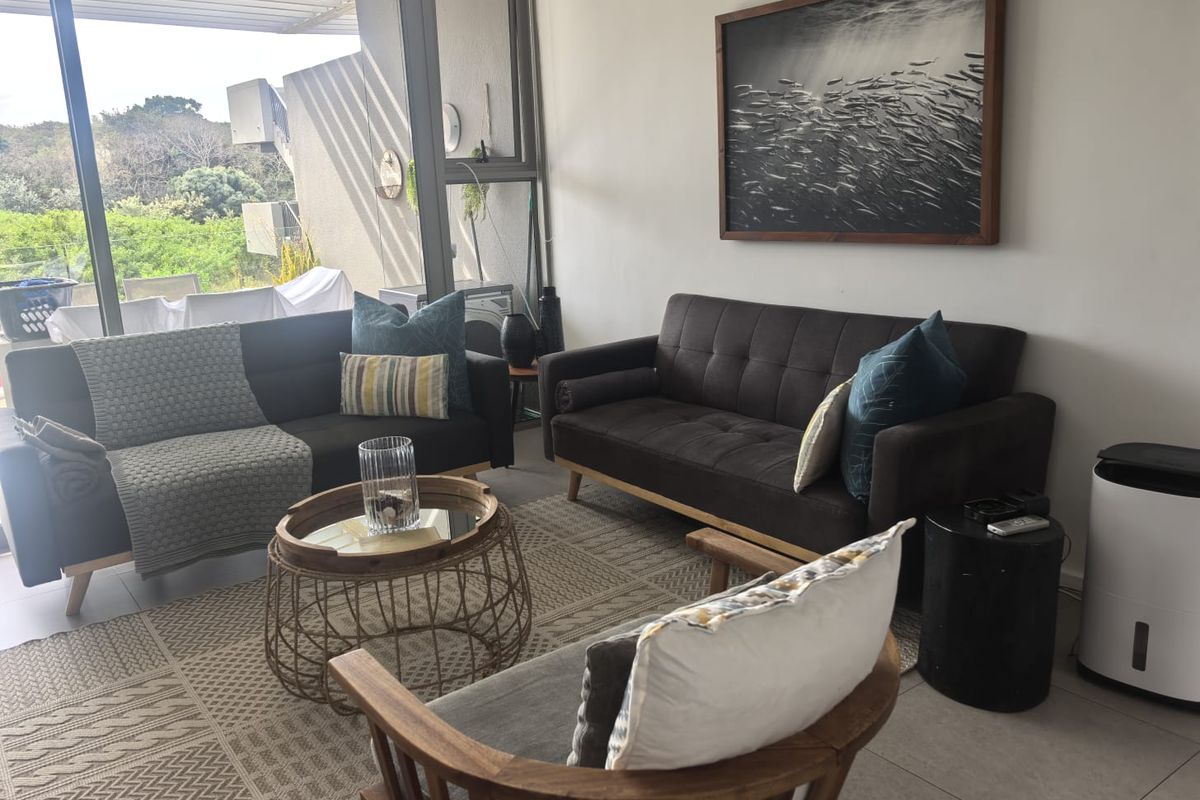 A bright living room featuring large sliding glass doors that provide natural light and access to an outdoor balcony area.