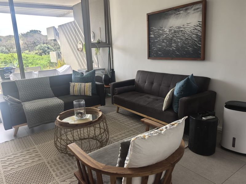 A bright living room featuring large sliding glass doors that provide natural light and access to an outdoor balcony area.