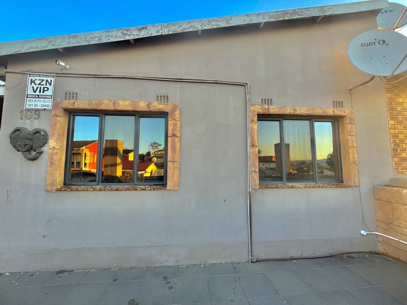 Front exterior view of the property featuring aluminium windows with decorative surrounds, security camera, and satellite dish installation.