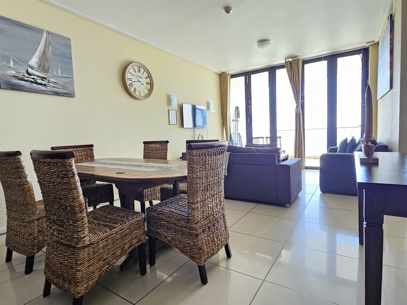 Open-plan living and dining area featuring large sliding glass doors that provide natural light and access to the balcony.