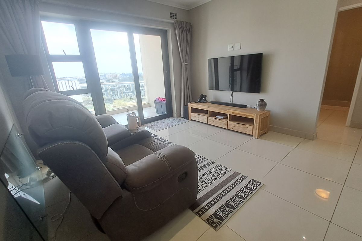 A modern living room featuring large sliding glass doors that provide natural light and access to an outdoor balcony area.