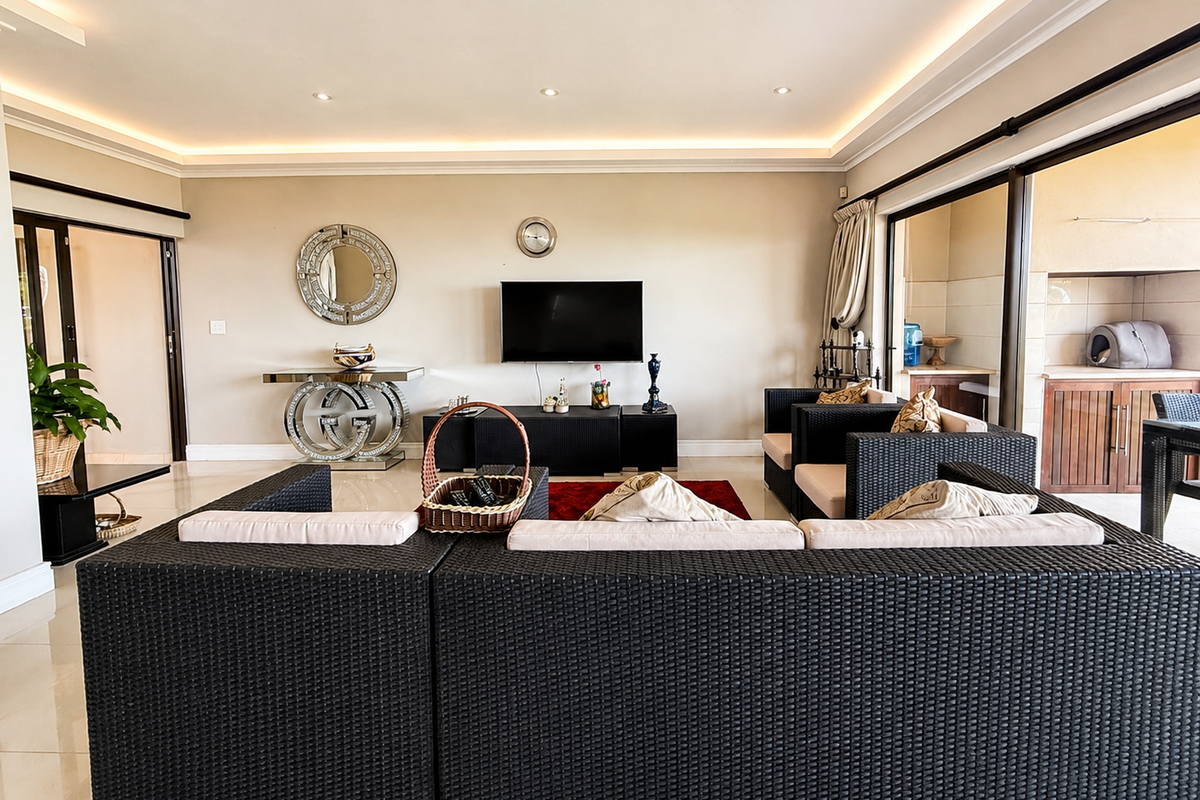 Spacious living room featuring recessed cove lighting, large sliding glass doors leading to an outdoor area, and polished tiled flooring.