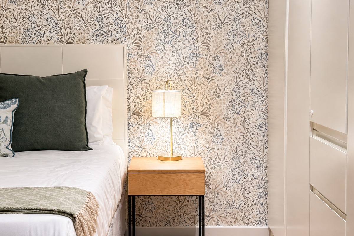 A well-appointed bedroom featuring decorative floral wallpaper and a sleek, integrated built-in wardrobe with clean lines.