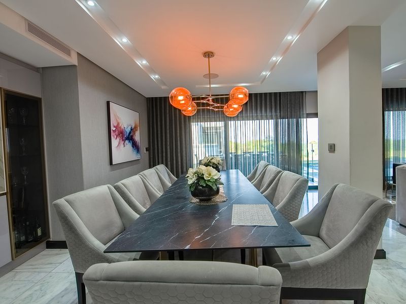 Elegant dining room featuring marble flooring, recessed ceiling lighting, and built-in cabinetry, with direct access to an outdoor area through sliding glass doors.