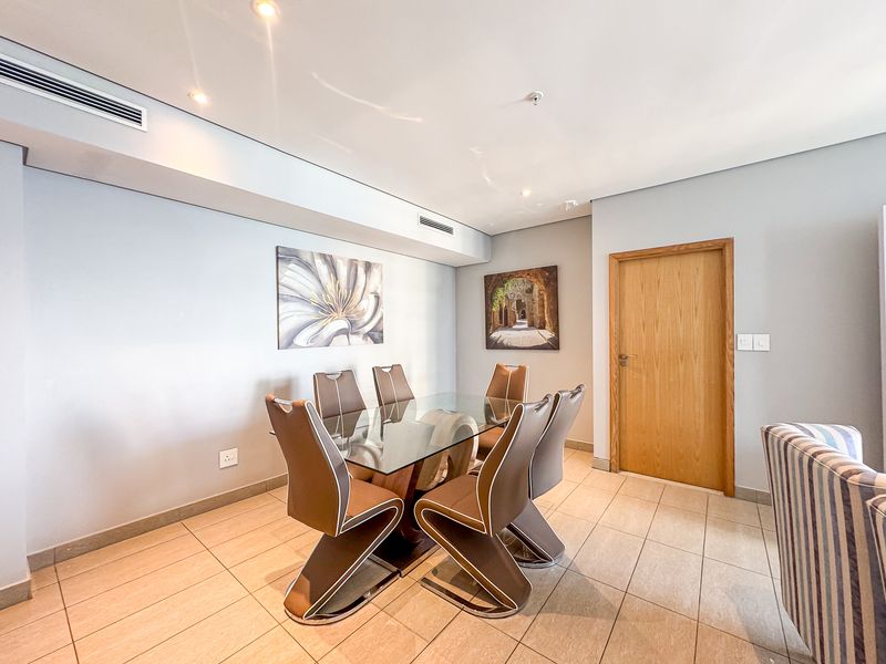 A well-maintained dining area featuring tiled flooring, recessed downlighting, and integrated ducted air conditioning.