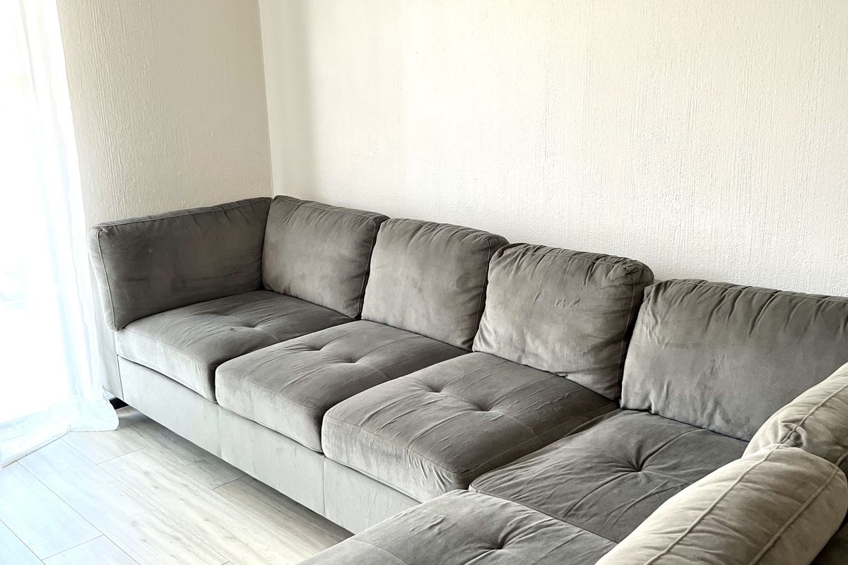 A bright living room area featuring light-toned laminate flooring and neutral wall finishes, providing a clean and comfortable space.