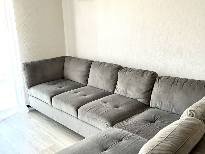 A bright living room area featuring light-toned laminate flooring and neutral wall finishes, providing a clean and comfortable space.
