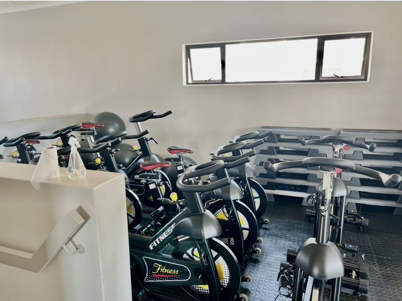 A dedicated gym space featuring durable rubber flooring and a high-set awning window for natural light.