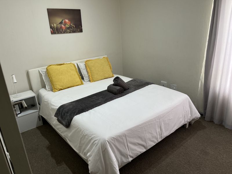 A standard bedroom featuring carpeted flooring and neutral wall finishes, providing a functional and comfortable sleeping space.