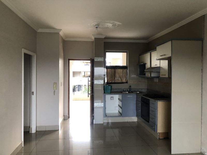 A compact kitchen featuring built-in cabinetry, granite countertops, and integrated appliances, requiring minor repairs and cosmetic updates to reach its full potential.