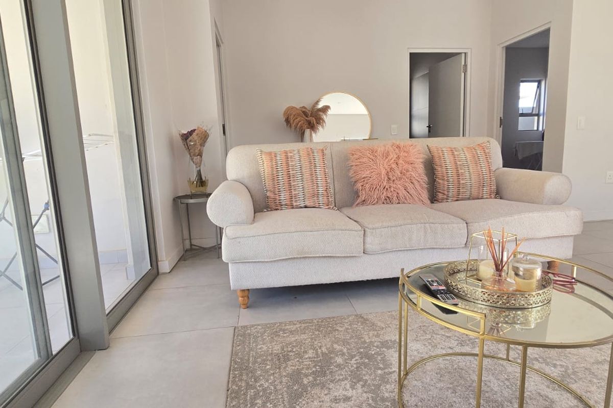 A bright and modern living room featuring large sliding glass doors that provide natural light and access to the outdoor area.