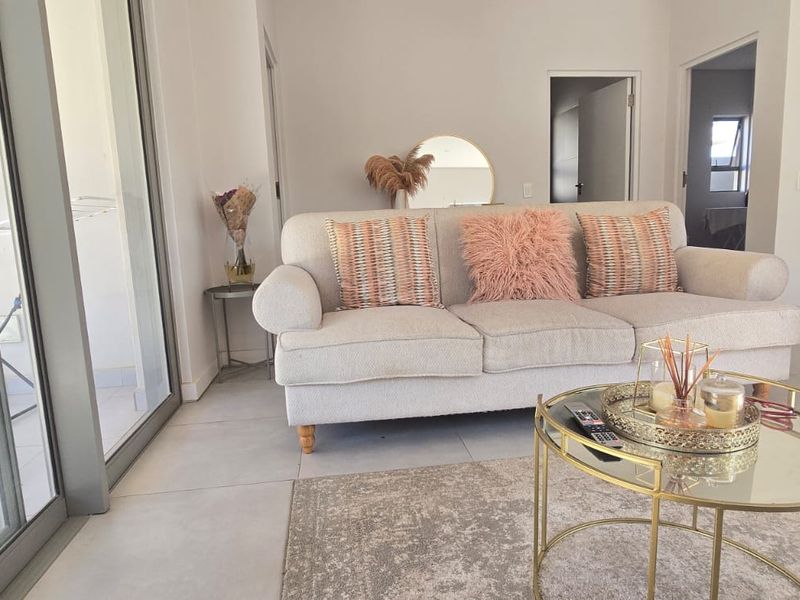 A bright and modern living room featuring large sliding glass doors that provide natural light and access to the outdoor area.