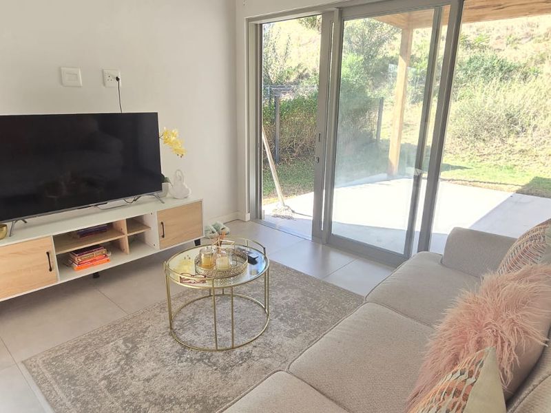 Modern living room featuring large sliding glass doors that provide natural light and direct access to the outdoor patio area.