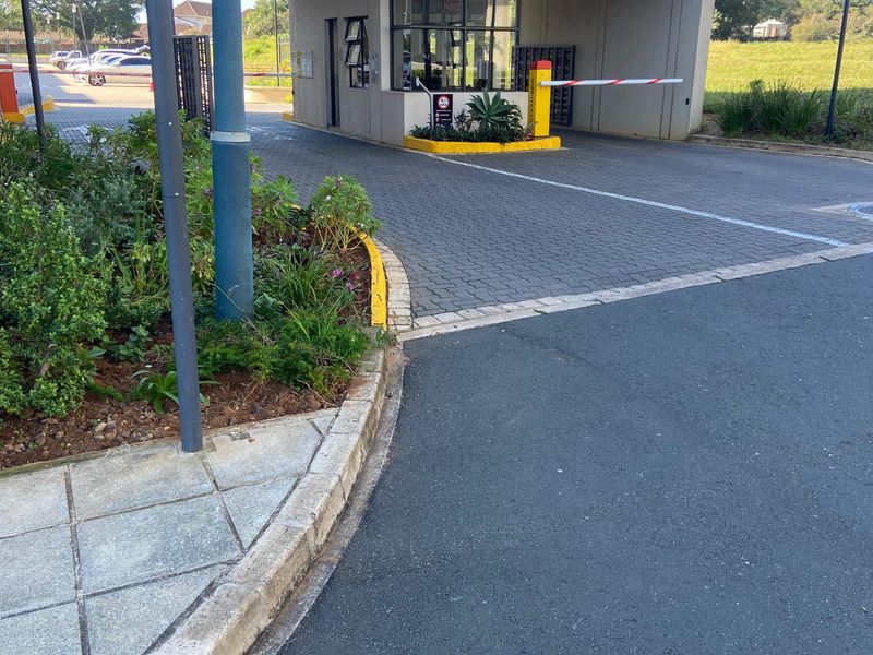 The secure entrance gatehouse for Ridge Town Central at 5 Summit Row, featuring a boom gate and paved access driveway.