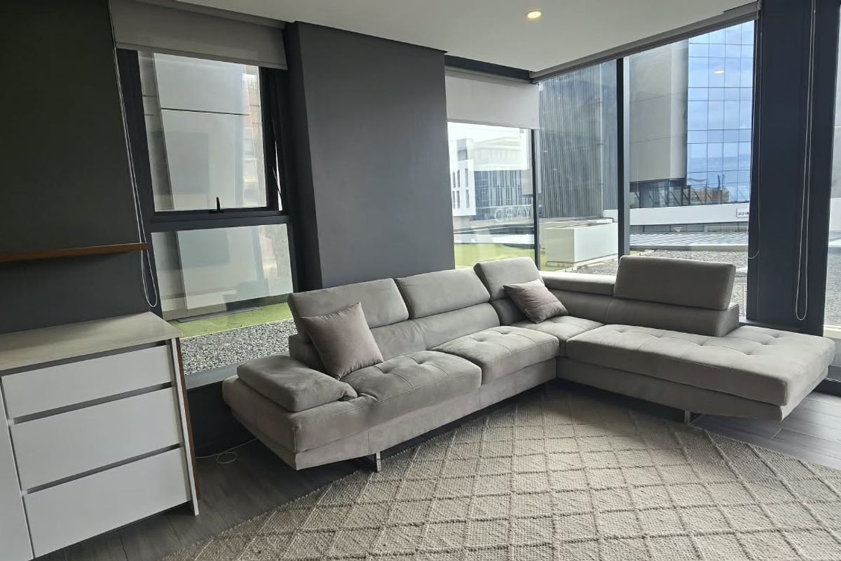 Modern living room featuring floor-to-ceiling windows, sleek dark walls, and high-quality laminate flooring, offering a bright and contemporary urban living space.