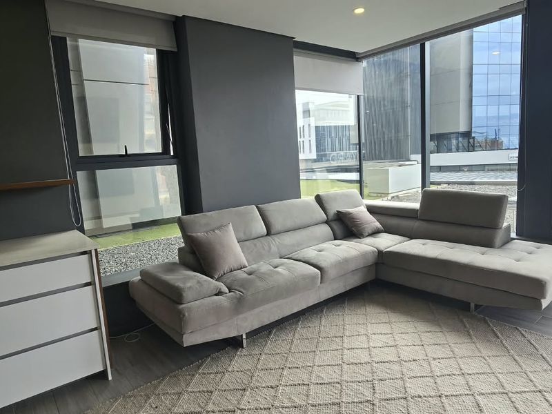 Modern living room featuring floor-to-ceiling windows, sleek dark walls, and high-quality laminate flooring, offering a bright and contemporary urban living space.