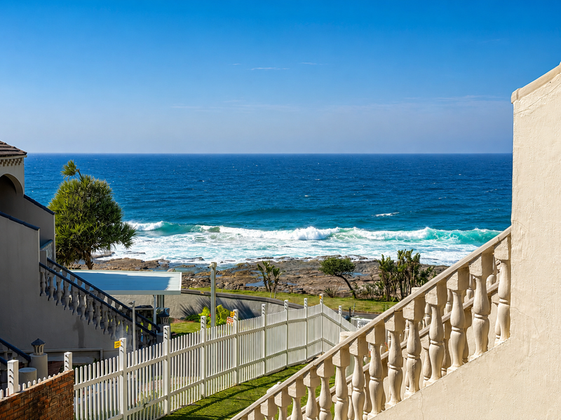 A scenic view of the ocean and rocky coastline captured from an elevated position with a decorative balustrade in the foreground.