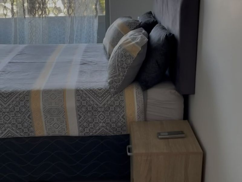 A well-lit bedroom featuring large windows that provide natural light and tiled flooring throughout.