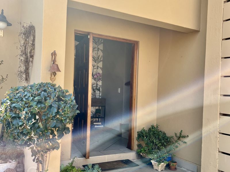 A welcoming covered entrance area featuring a tiled threshold and exterior lighting, providing a clear view into the home's interior.