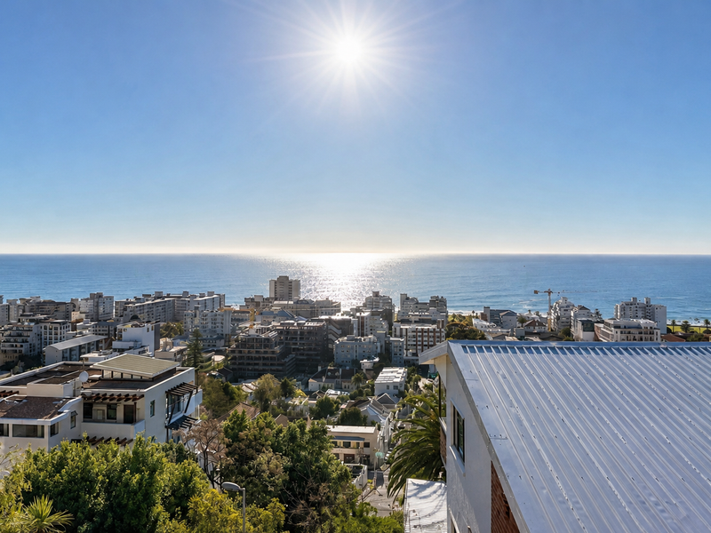 A panoramic elevated view overlooking the coastal cityscape and the ocean horizon under a clear sunny sky.