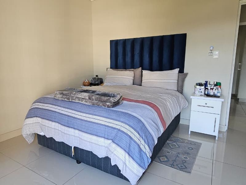 A well-maintained bedroom featuring neutral wall tones, polished tiled flooring, and clean architectural finishes.