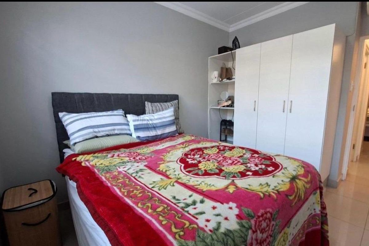 A bedroom featuring tiled flooring, a built-in wardrobe, and decorative cornice detailing.