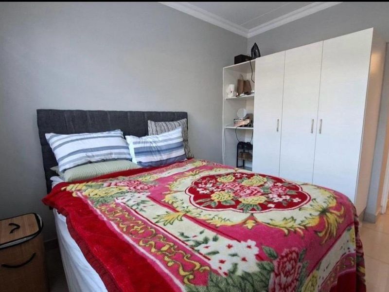 A bedroom featuring tiled flooring, a built-in wardrobe, and decorative cornice detailing.