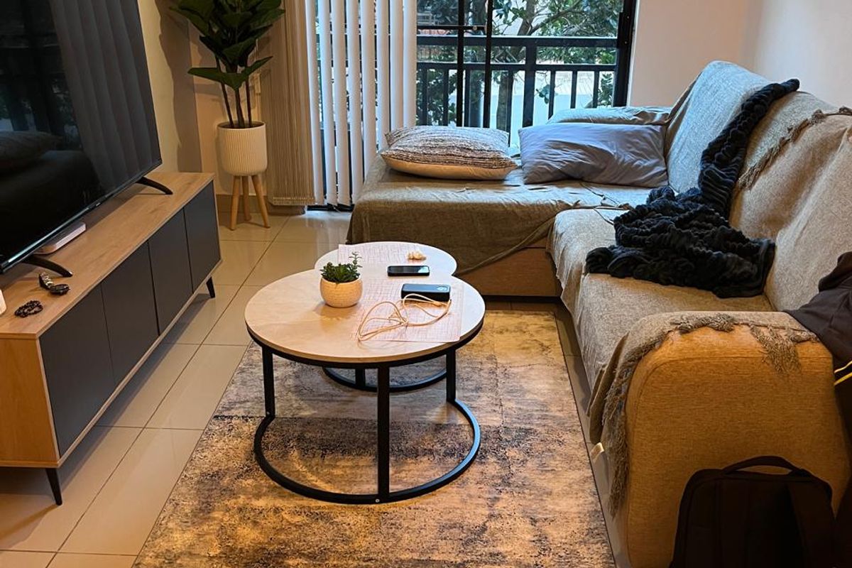 A comfortable living room featuring tiled flooring and a large sliding glass door with vertical blinds, providing access to an outdoor balcony area.