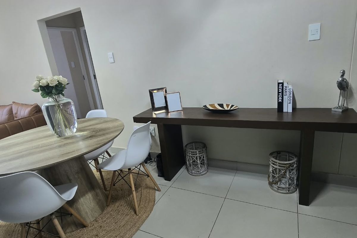 A well-maintained living area featuring neutral tiled flooring and clean wall finishes, providing a versatile space for dining or relaxation.