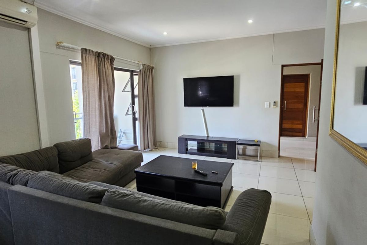 A living room featuring tiled flooring, recessed lighting, and a sliding glass door leading to an outdoor area.