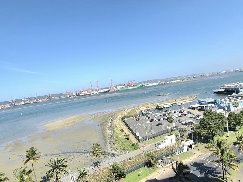 Elevated panoramic view overlooking the harbor, coastline, and surrounding urban landscape from the apartment balcony.