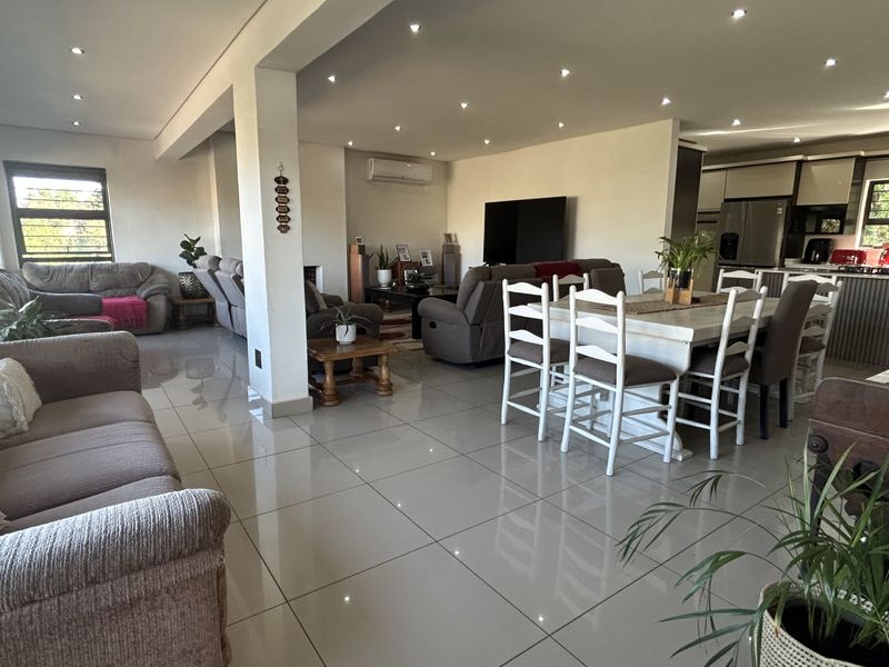 Spacious open-plan living and dining area featuring polished porcelain floor tiles, recessed lighting, and a seamless flow into the modern kitchen space.